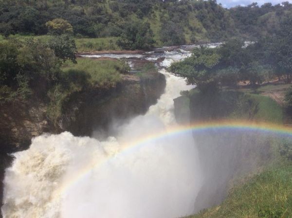 A waterfall with a rainbow in the middle of it