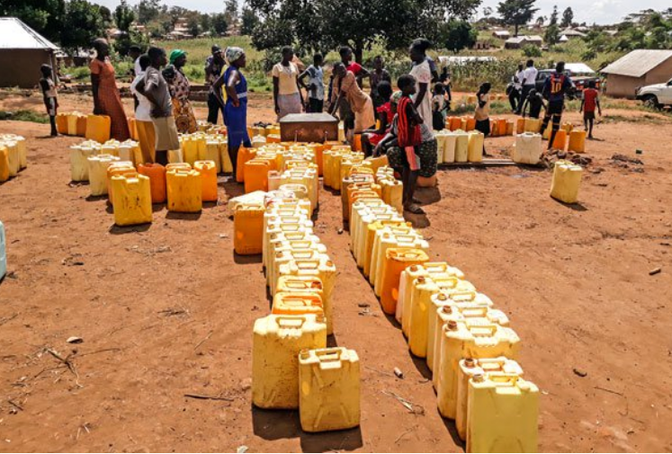 Water well in Africa with the people and jugs lined up