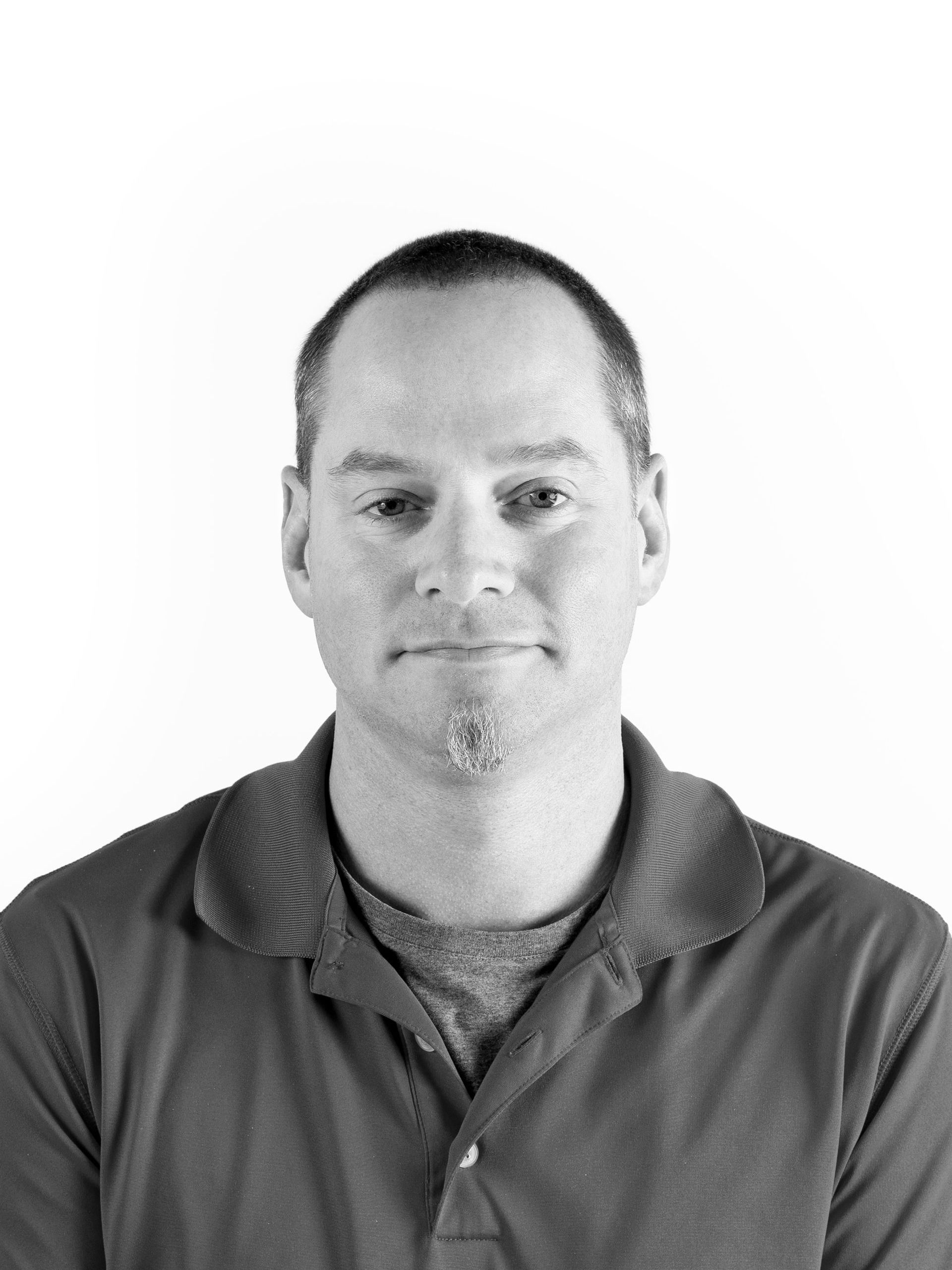 A black and white photo of a man wearing a polo shirt
