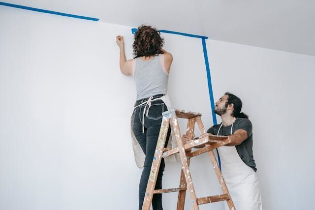 two+people+putting+up+painters+tape