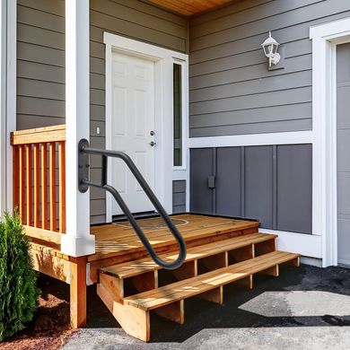 A wooden porch with stairs leading up to the front door of a house