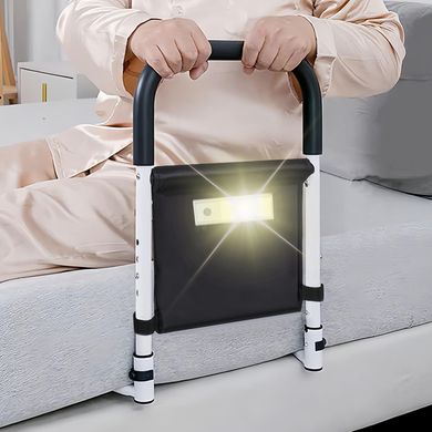 A person is sitting on a couch holding a railing with a light on it.