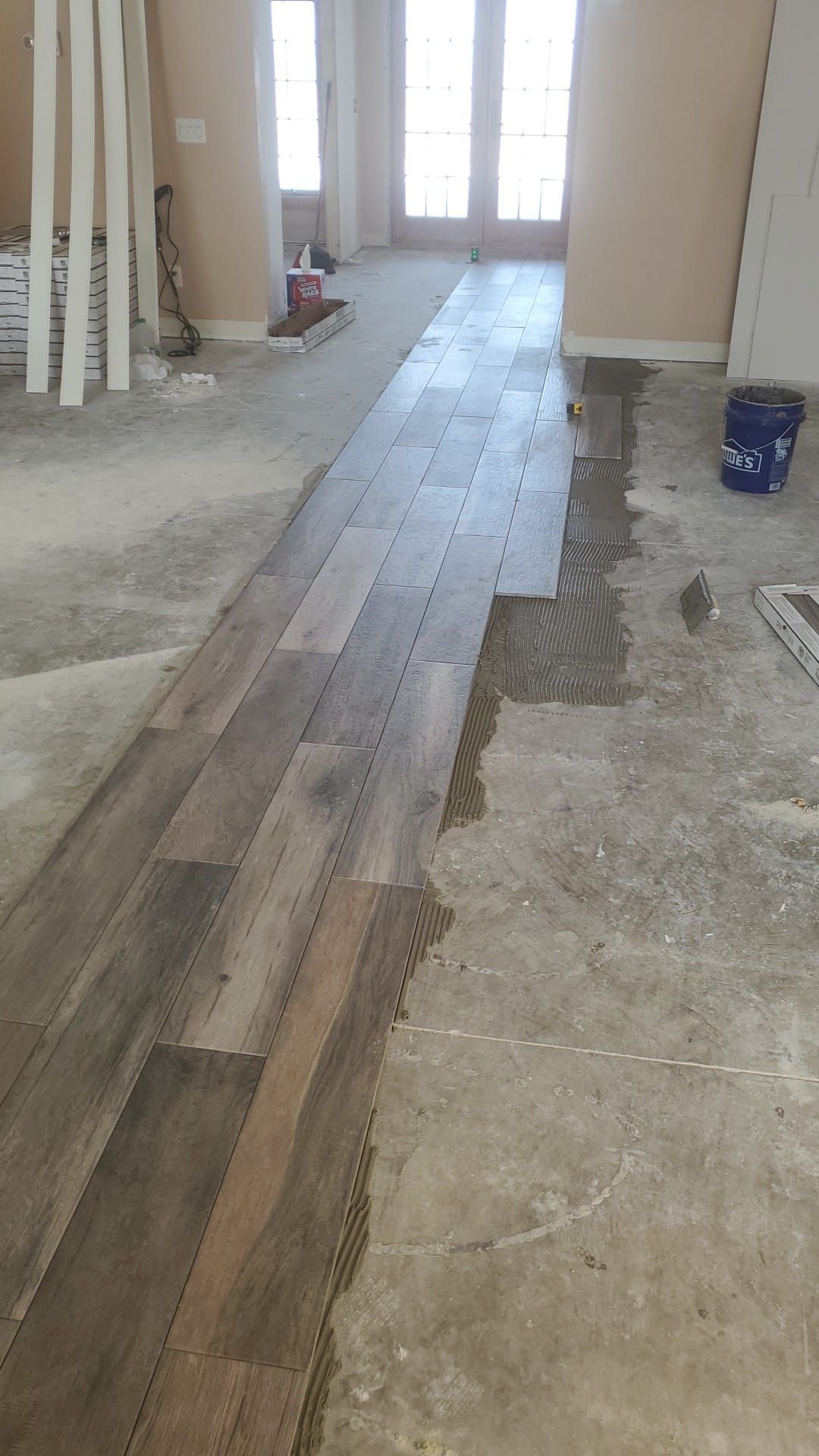 A wooden floor is being installed in a living room.