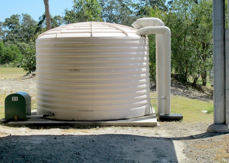White Water Tank with A Green Pump Attached to It — Rosewood Environmental Services Pty Ltd in Taree, NSW