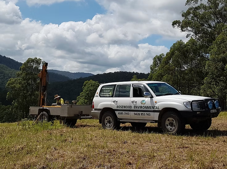 Two Green Water Tanks Are Sitting on A Brick Driveway — Rosewood Environmental Services Pty Ltd in Port Macquarie, NSW