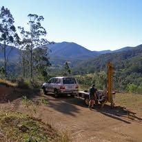 SUV with drilling equipment on a dirt road, mountains in background, man working — Rosewood Environmental Services Pty Ltd in Wauchope, NSW