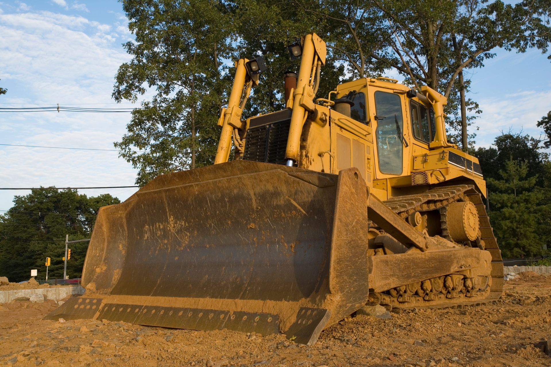 Yellow bulldozer on a construction site, pushing dirt.