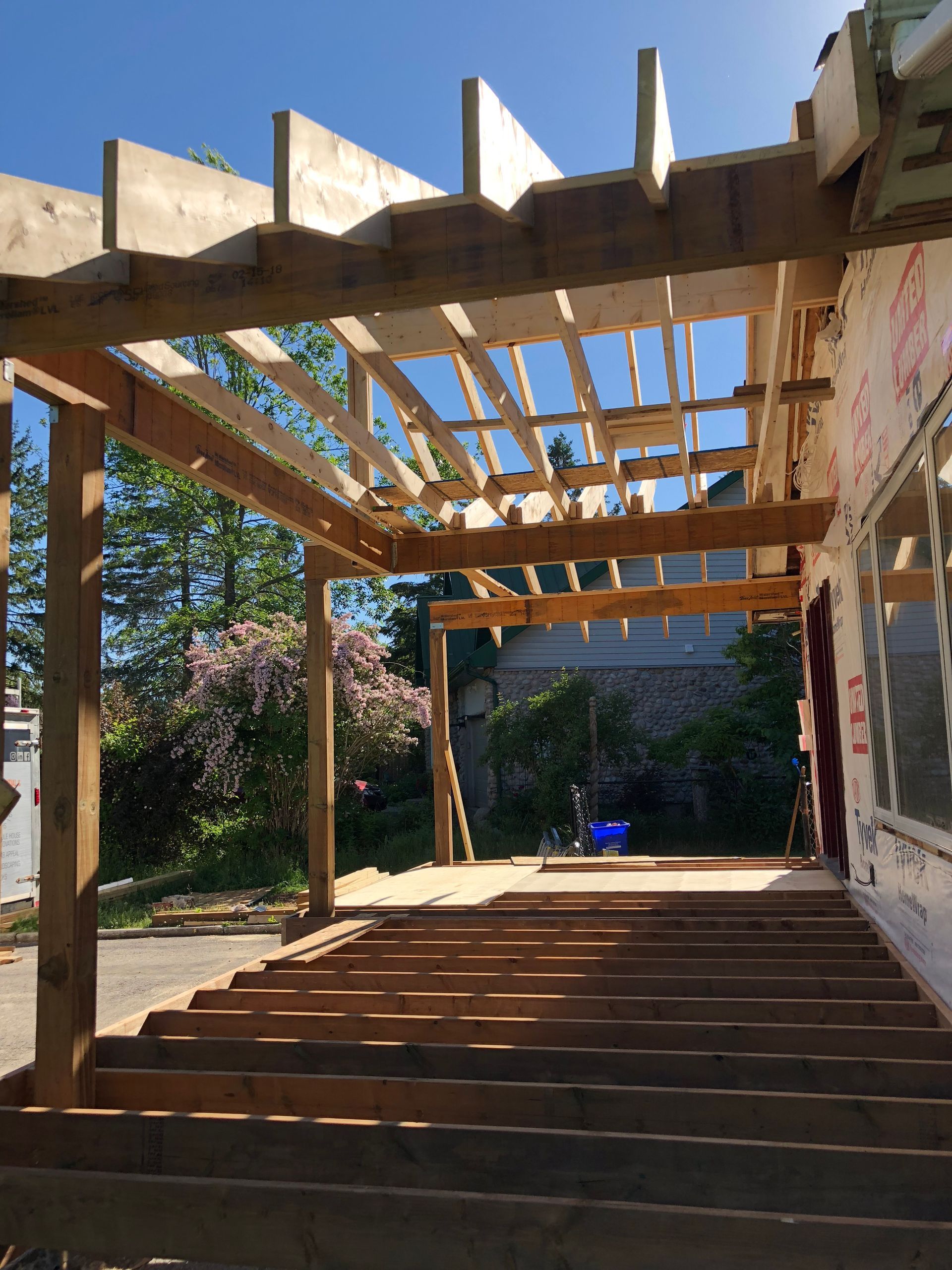 A wooden structure is being built on the side of a house