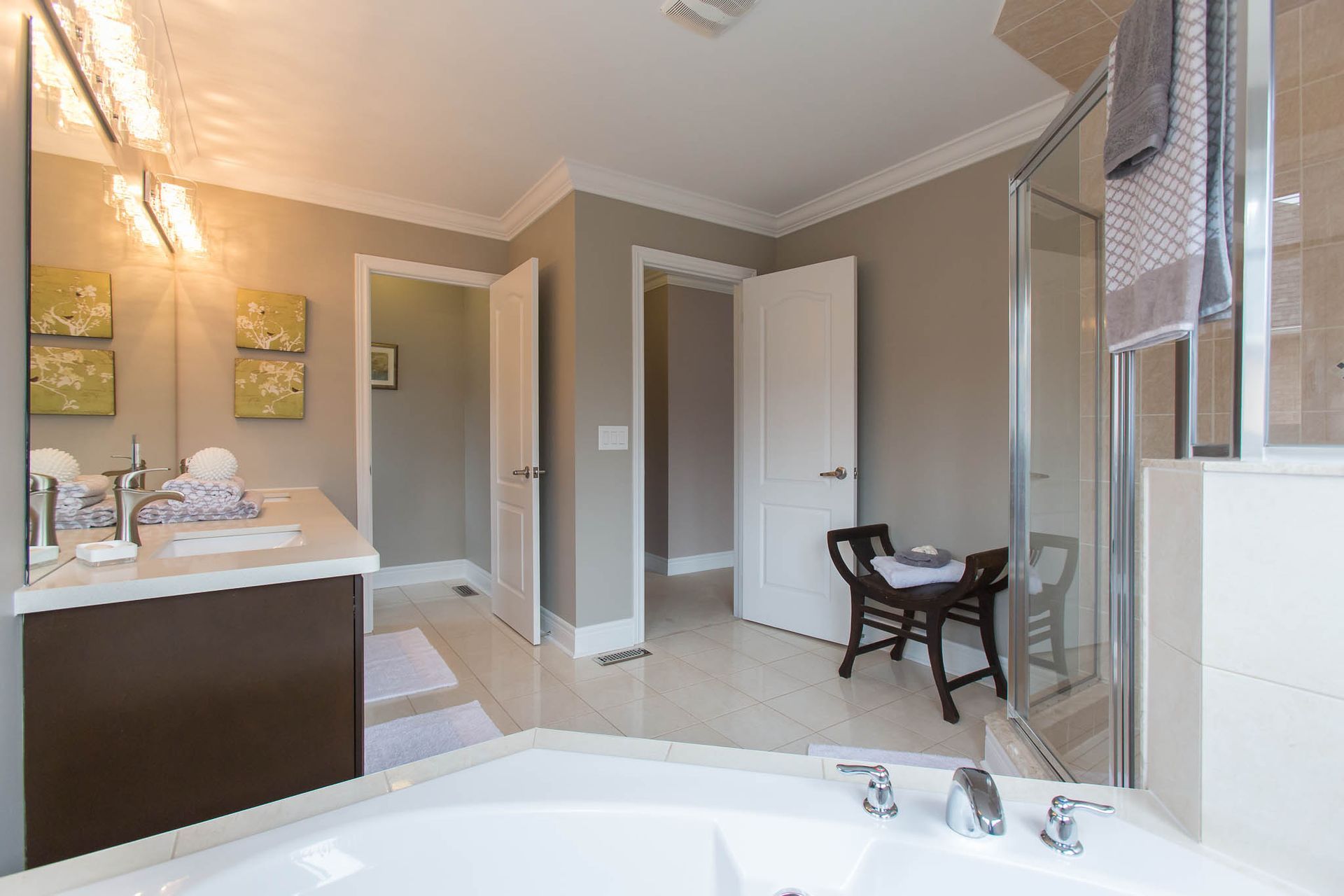 A bathroom with a tub, sink, mirror and shower.