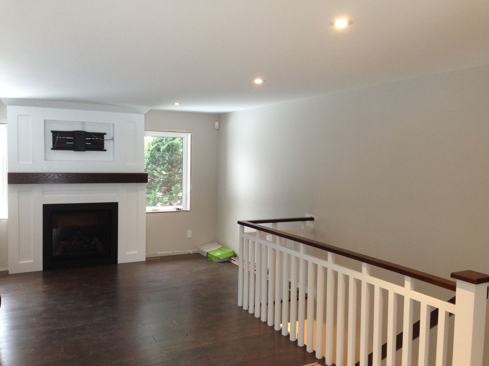 An empty living room with a fireplace and stairs