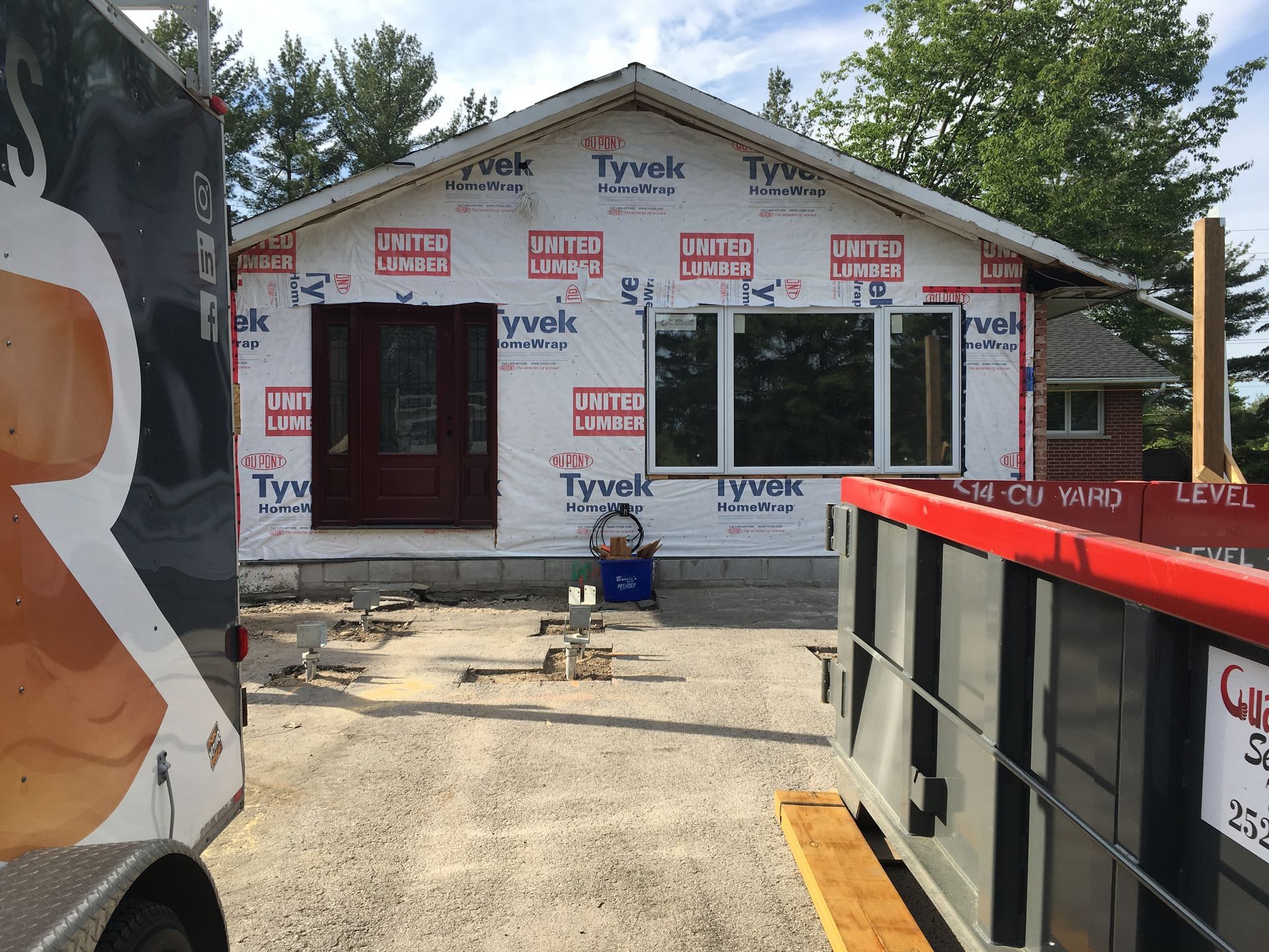 A truck is parked in front of a house that is being built