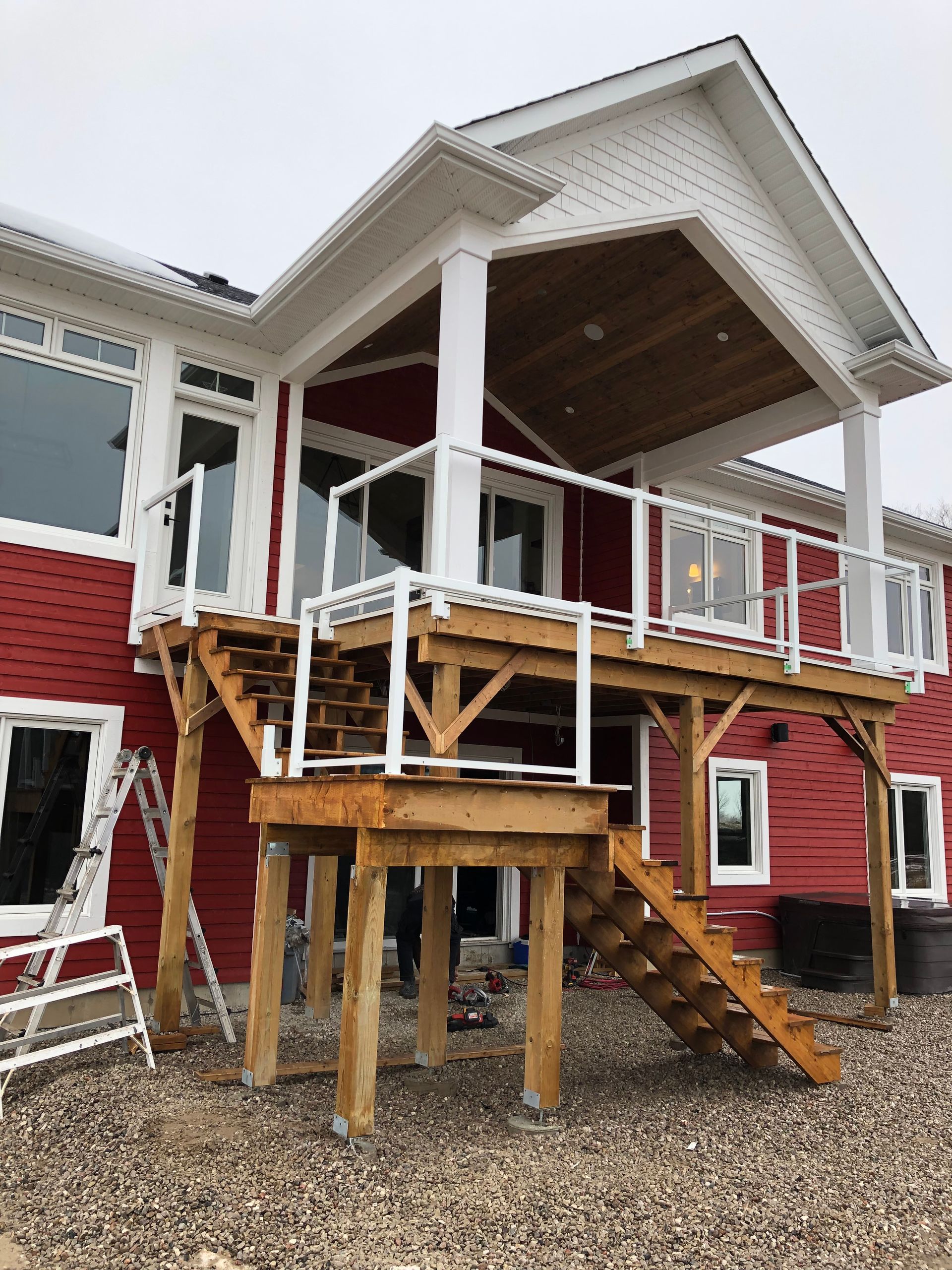 A red house with a wooden deck and stairs