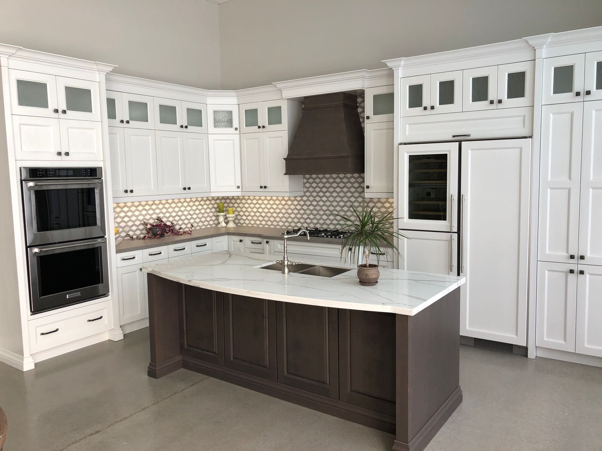A kitchen with white cabinets and a large island in the middle.