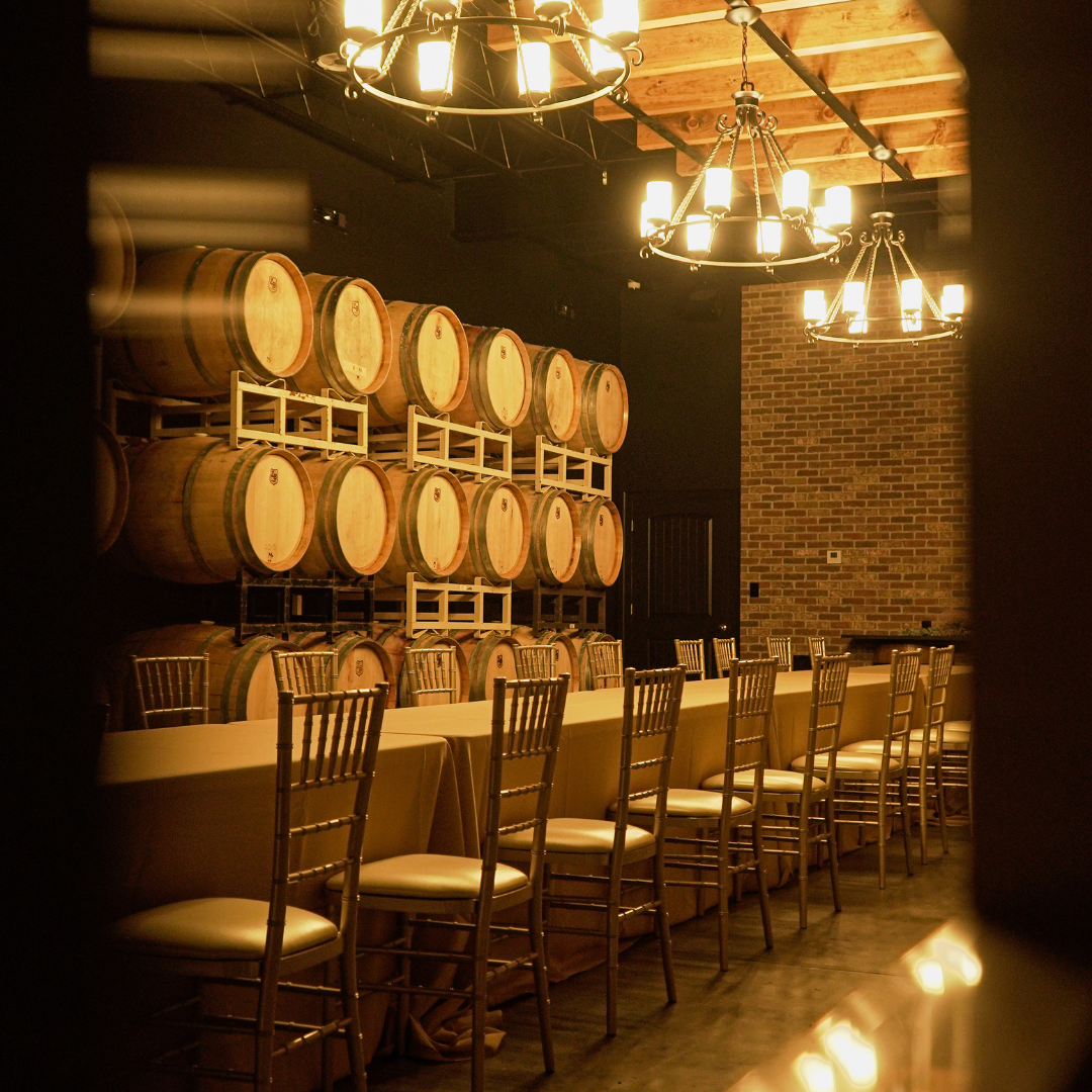 Rows of wooden barrels are lined up in a dark room