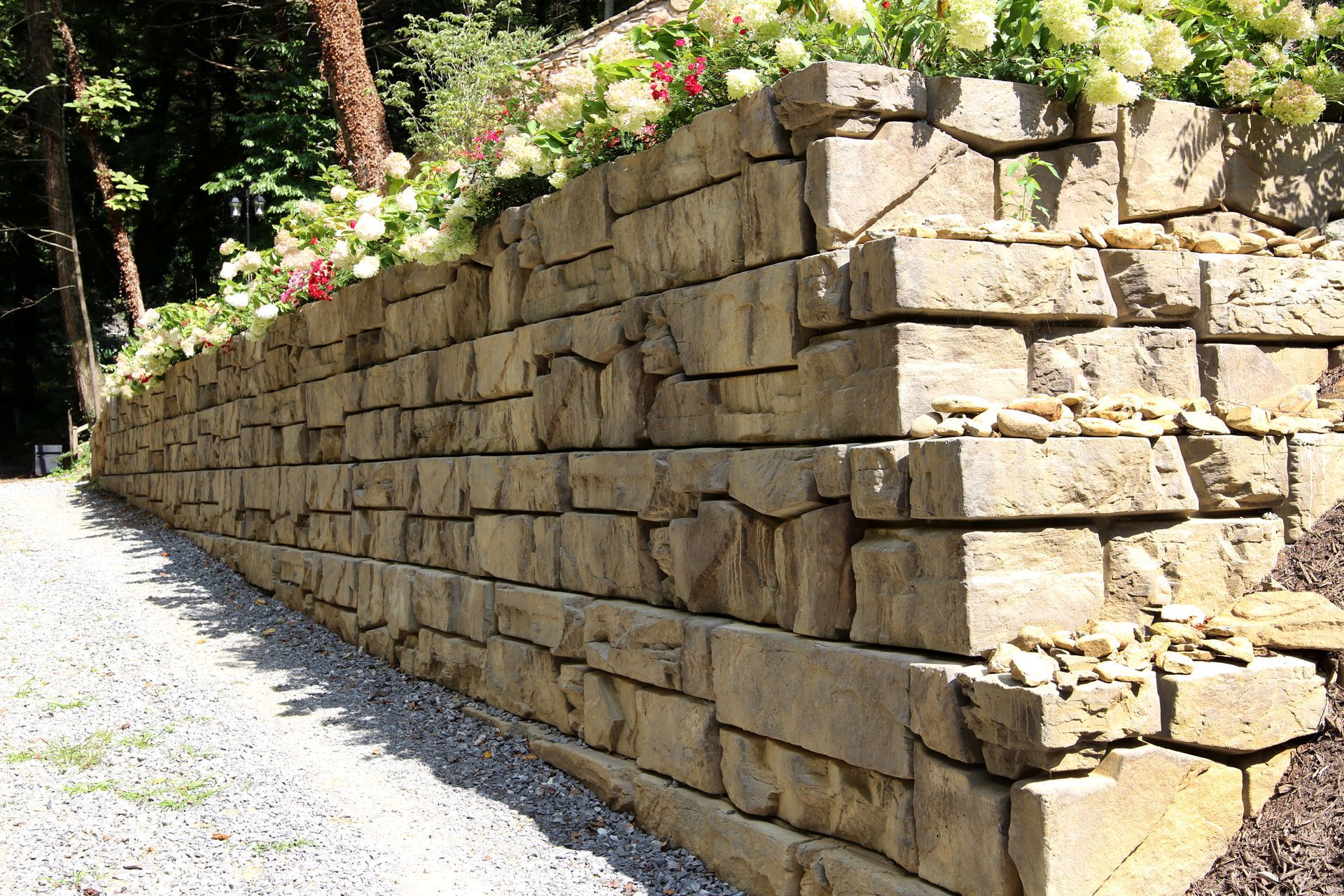 A large stone wall with flowers growing on it