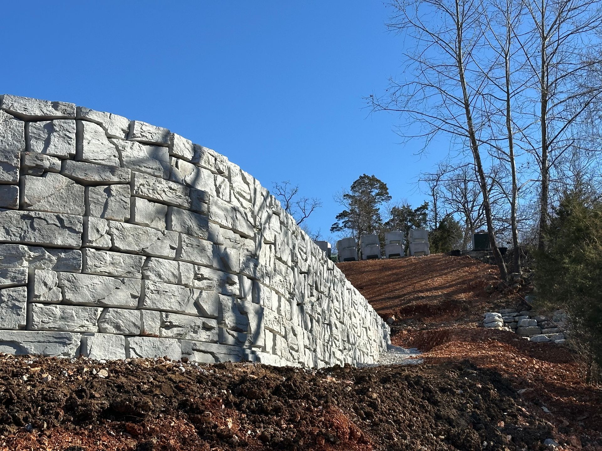 A large stone wall with trees in the background
