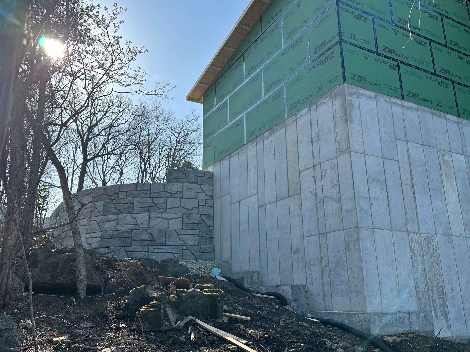 A house is being built next to a stone wall.