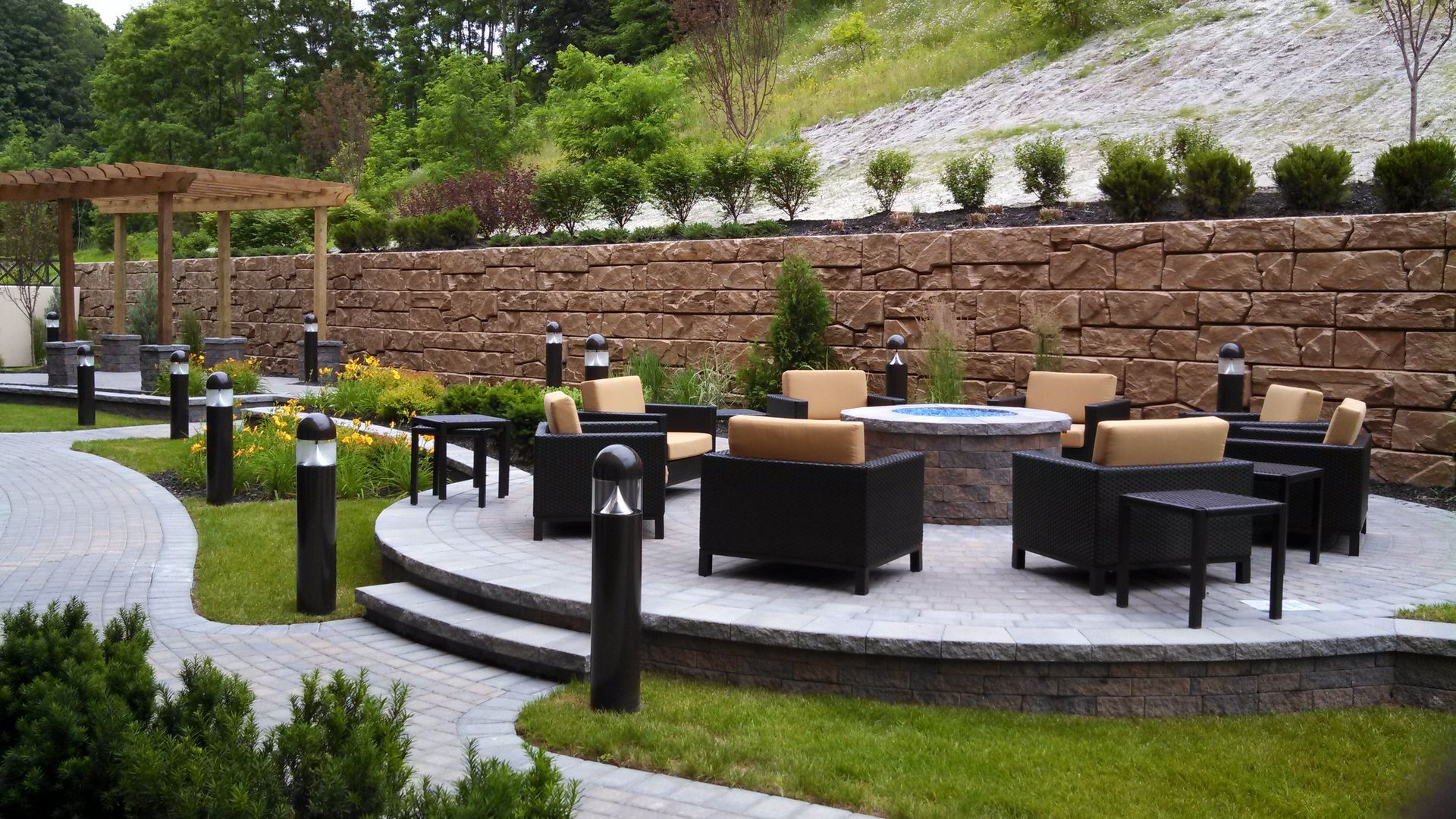 A patio with chairs and a fire pit in the middle of it