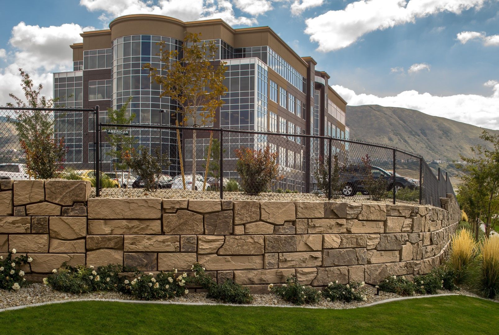 A large building with a stone wall in front of it