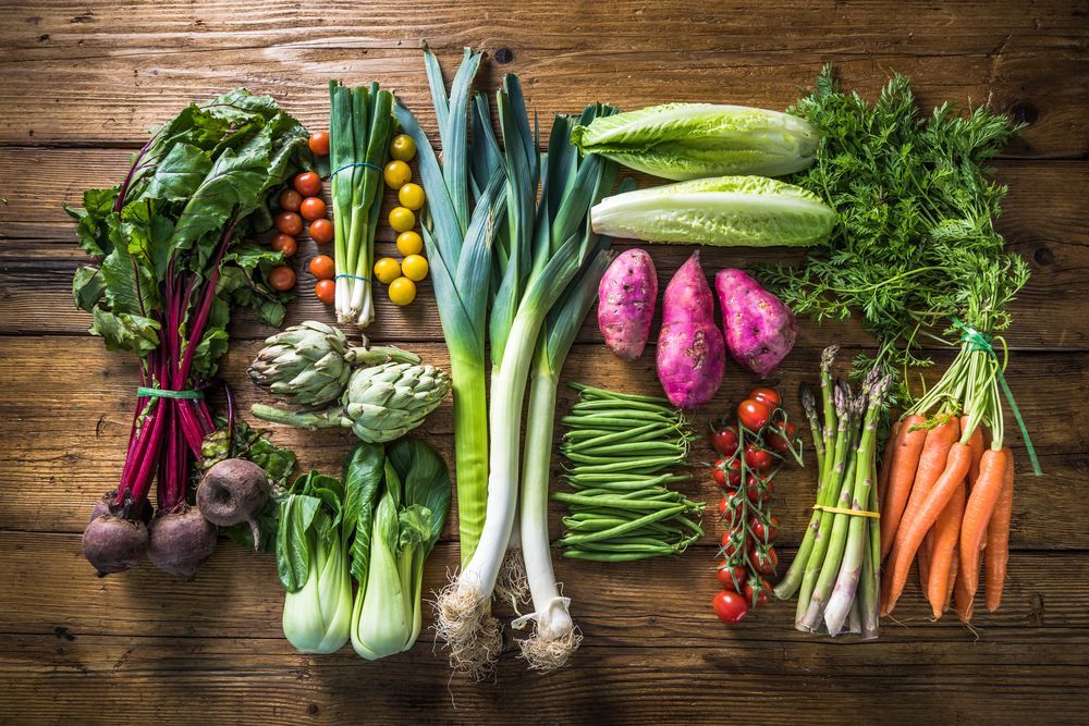 A wooden table topped with a variety of fresh vegetables.
