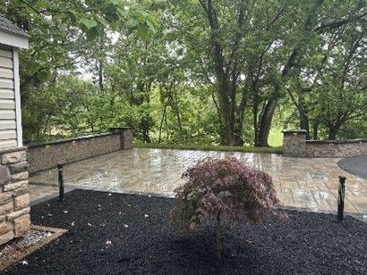 Stone patio with retaining wall and trees in the background. Stone patio with retaining wall and trees in the background.