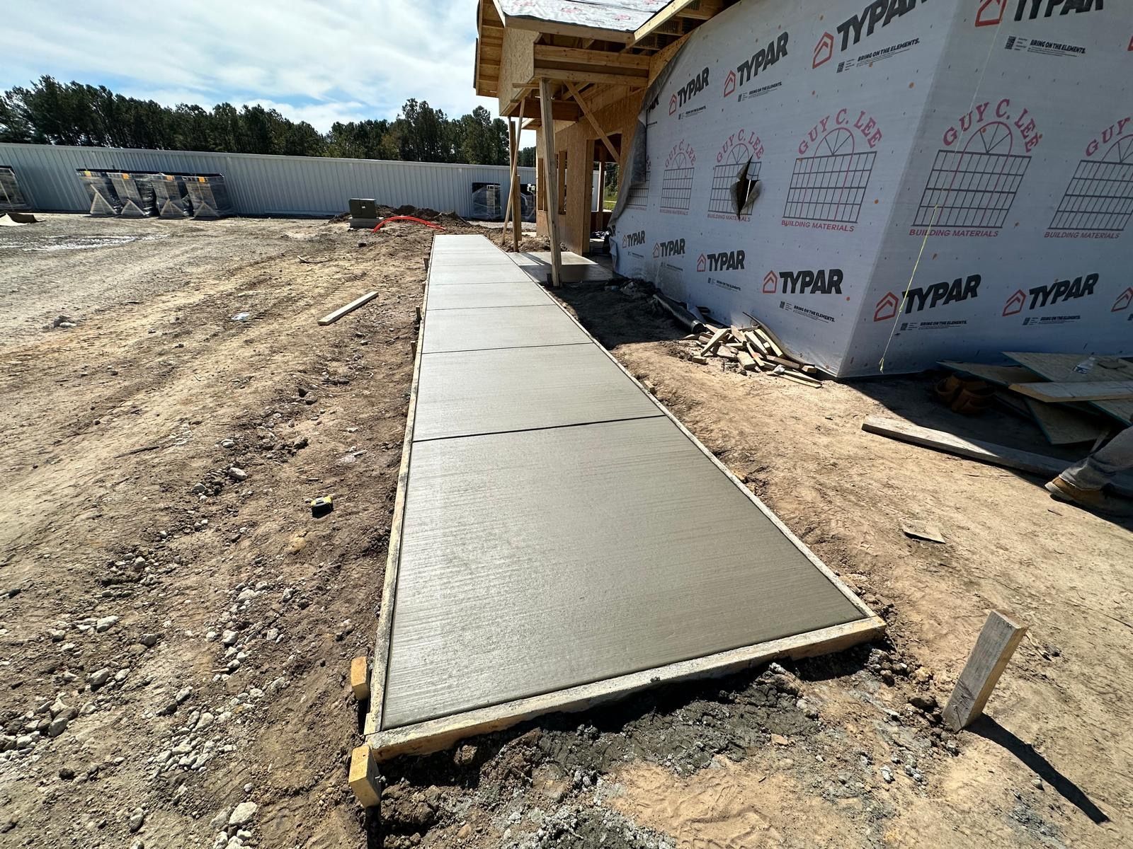 A concrete walkway is being built in front of a building