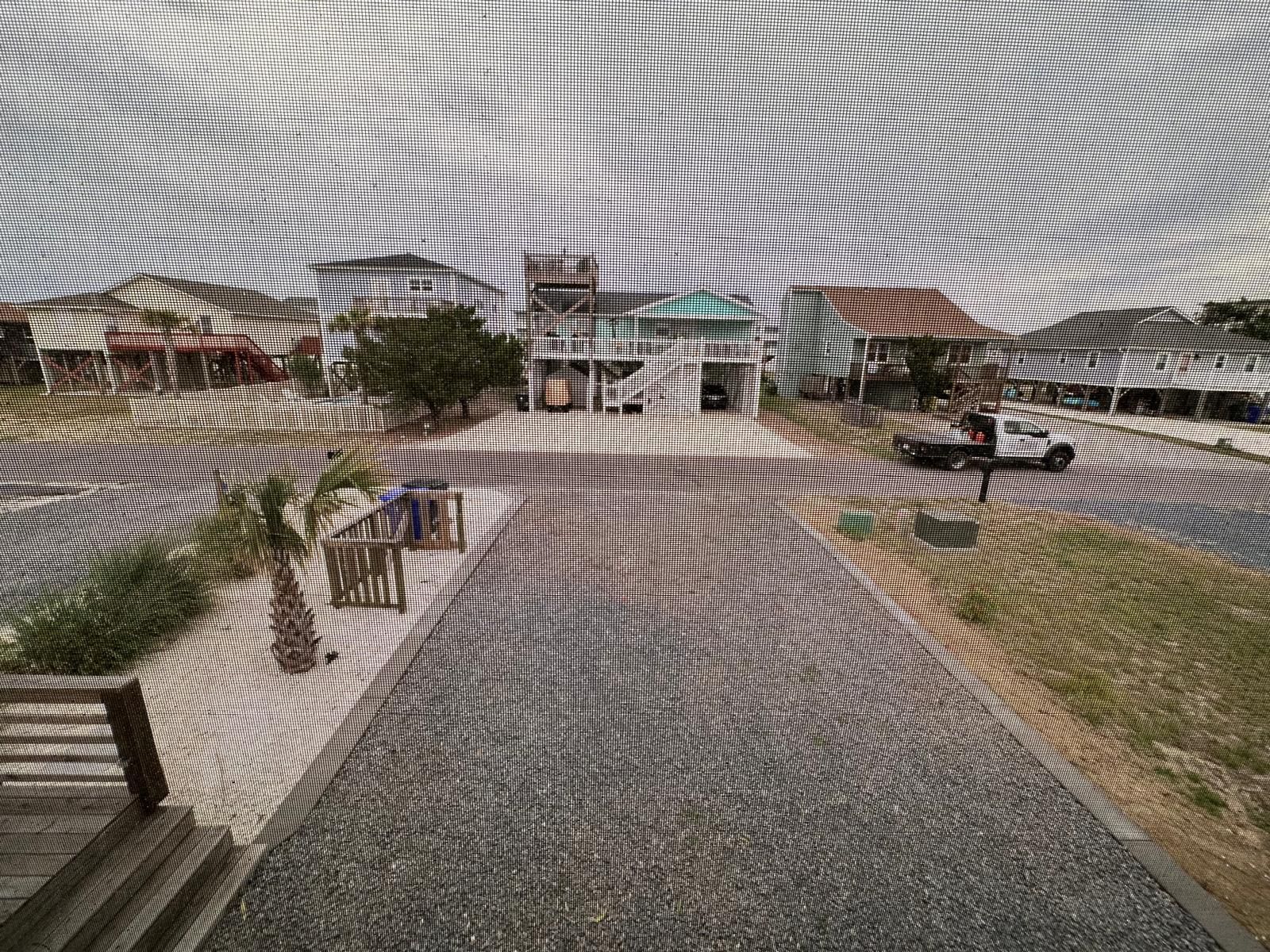 A blurred image of a road with houses in the background.