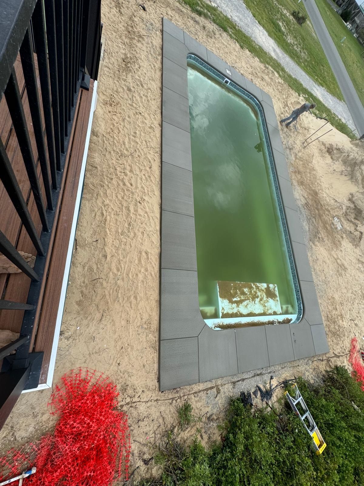 An aerial view of a swimming pool with a green water.