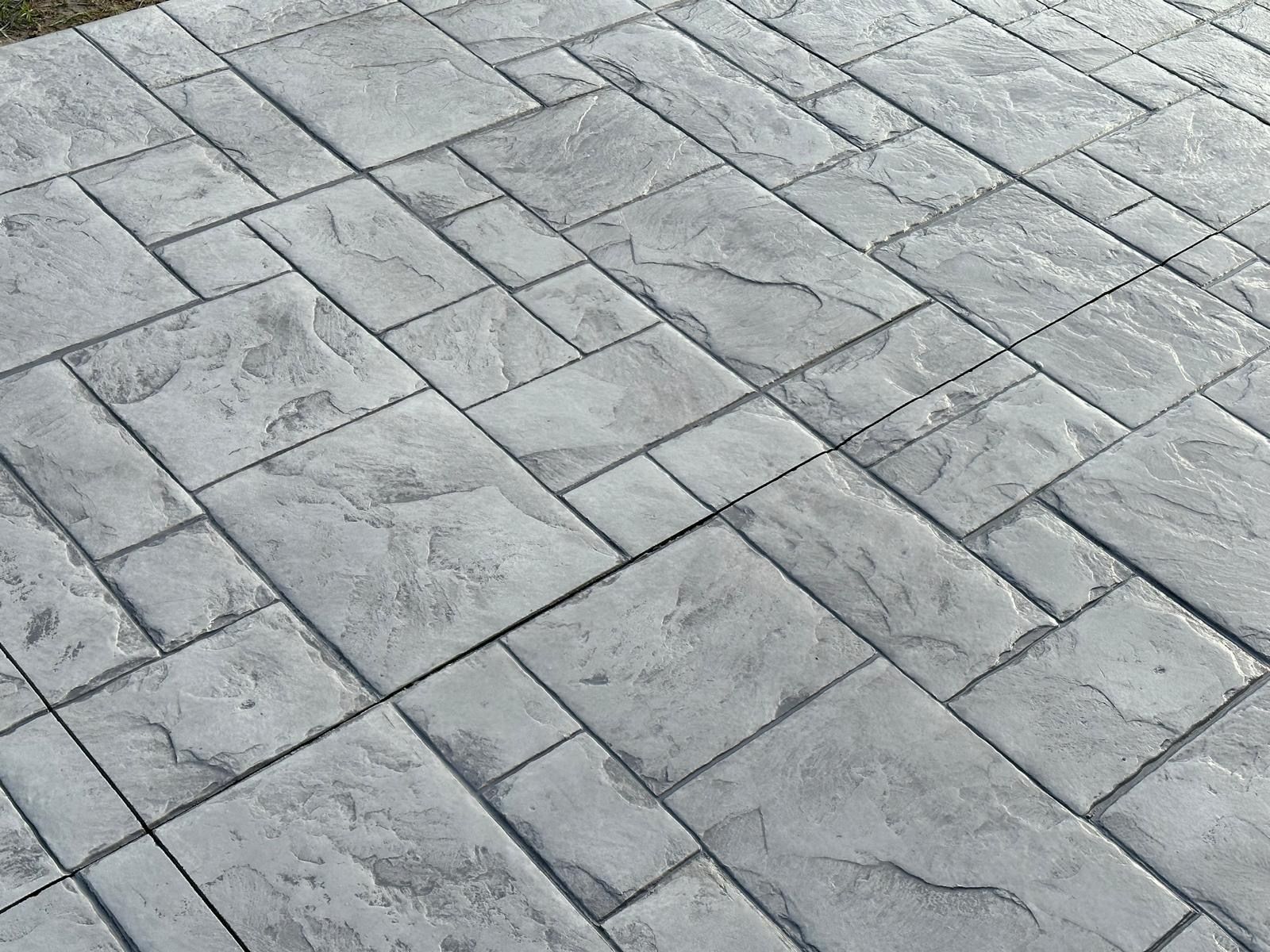 A close up of a gray brick pavement with a pattern.