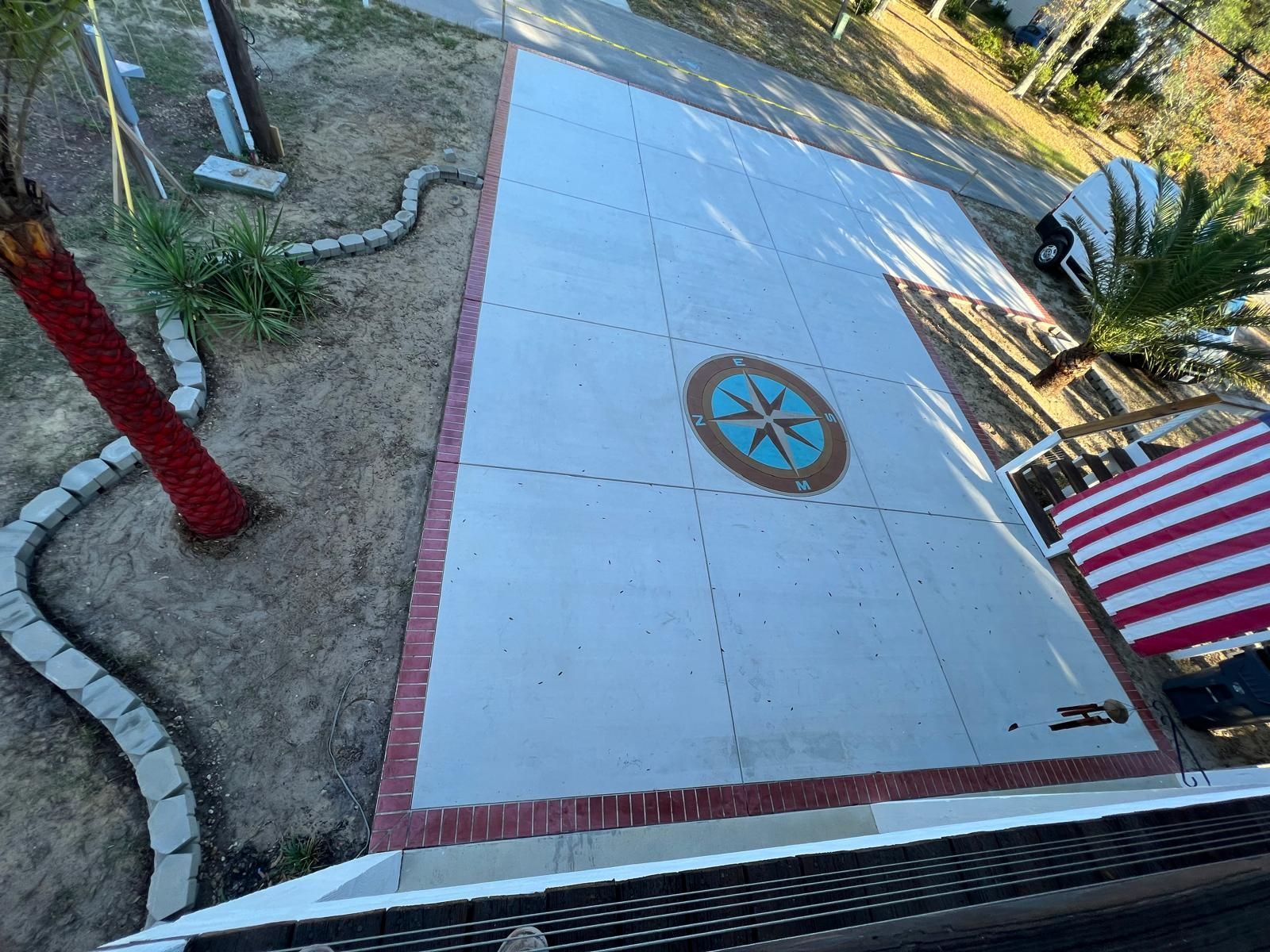An aerial view of a concrete driveway with a compass on it