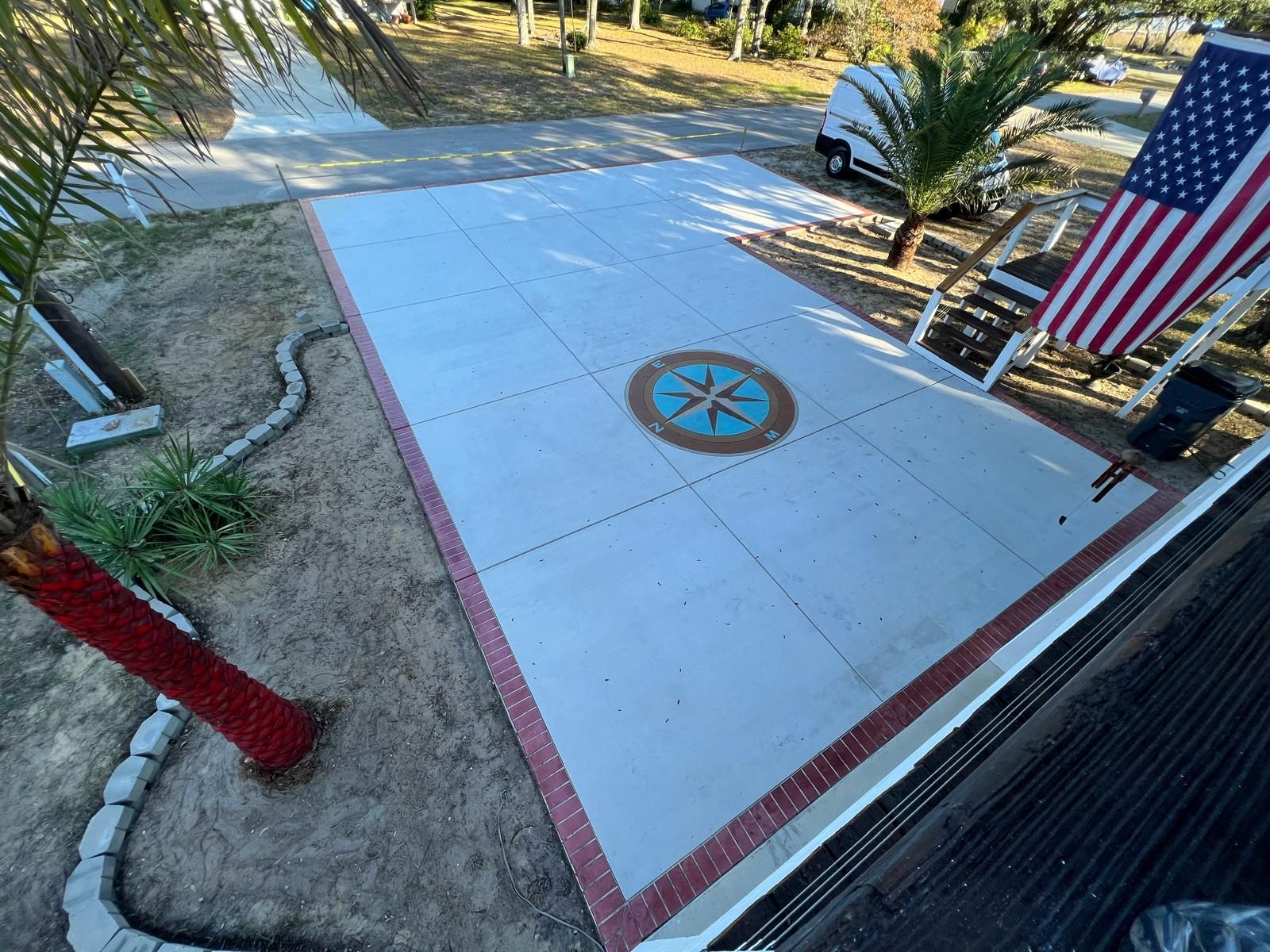 A concrete driveway with a compass and an american flag painted on it.