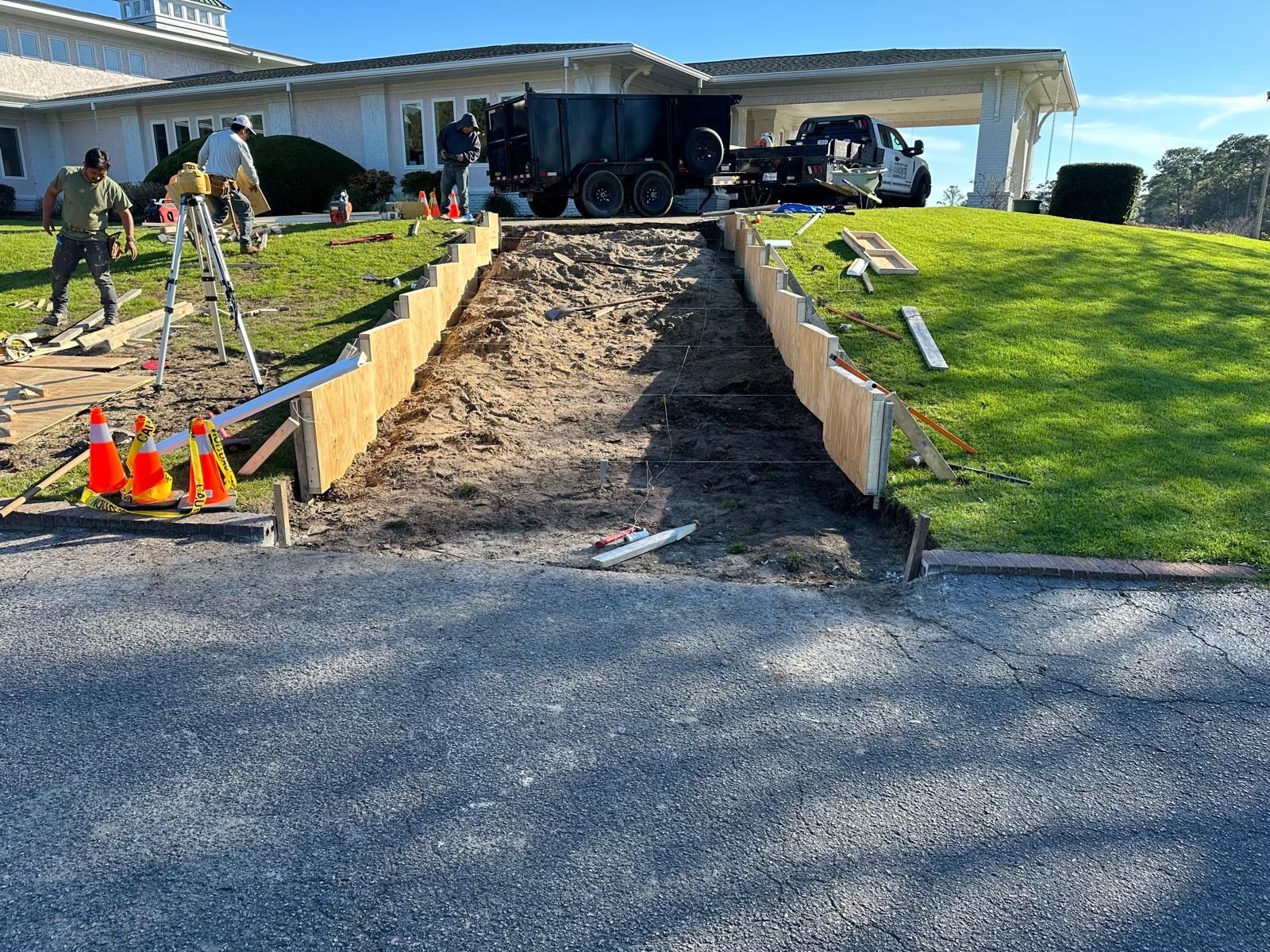A concrete driveway is being built in front of a house.