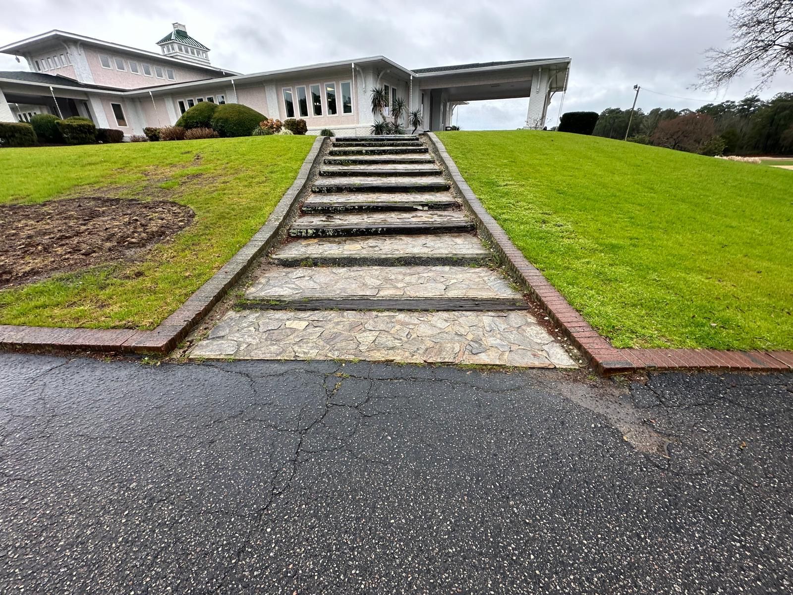 A set of stairs leading up to a house on a hill.
