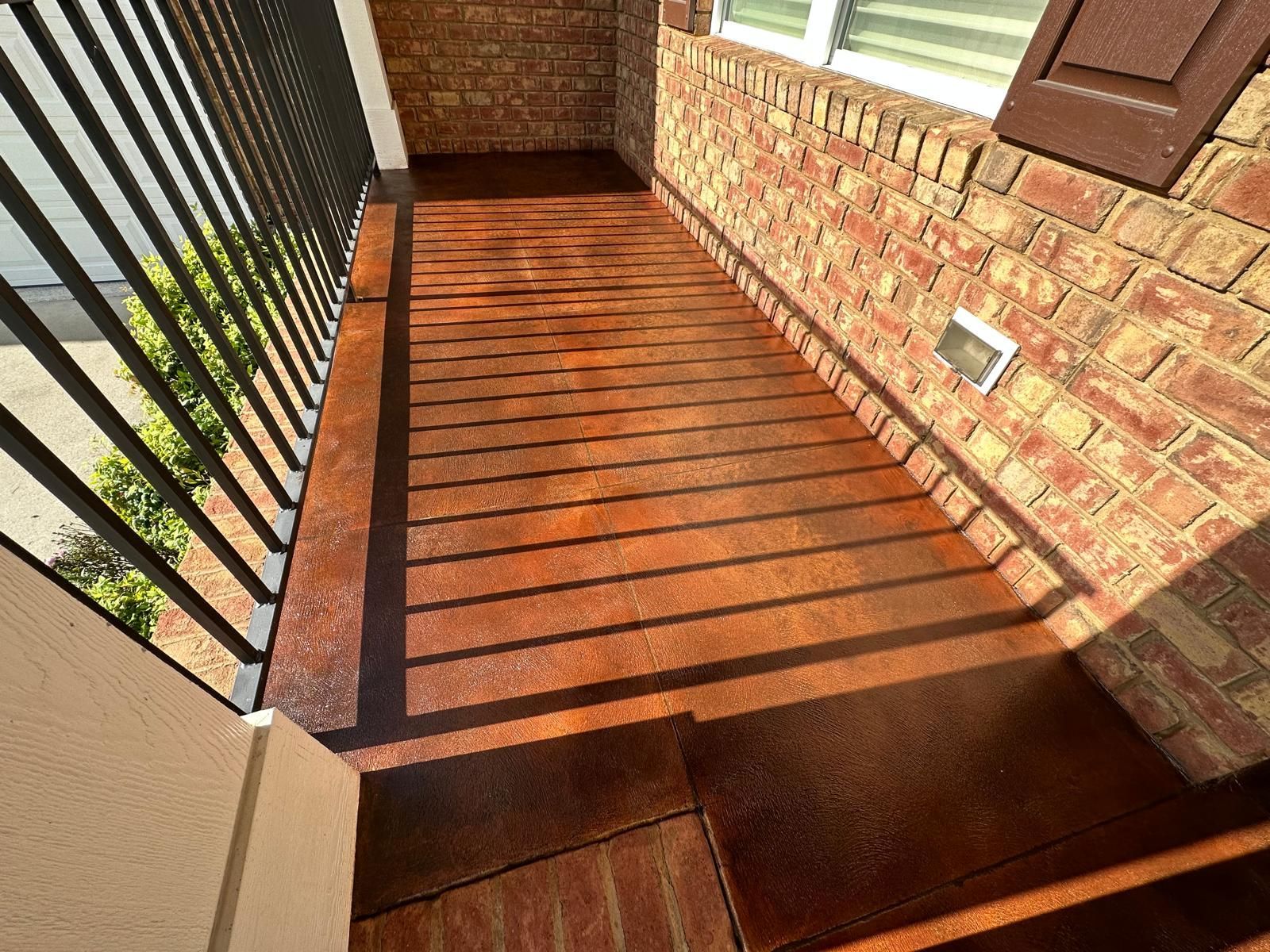 A balcony with a brick wall and a wooden floor.