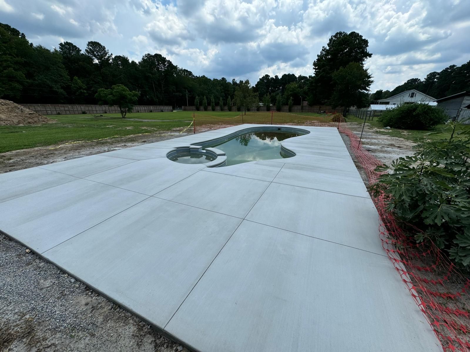 A concrete driveway with a pool in the middle of it