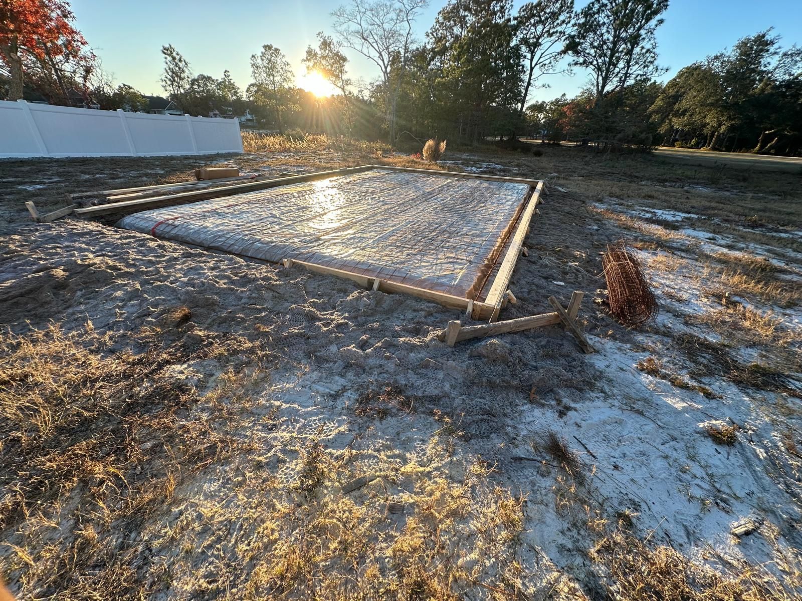 A large concrete slab is sitting in the middle of a dirt field.