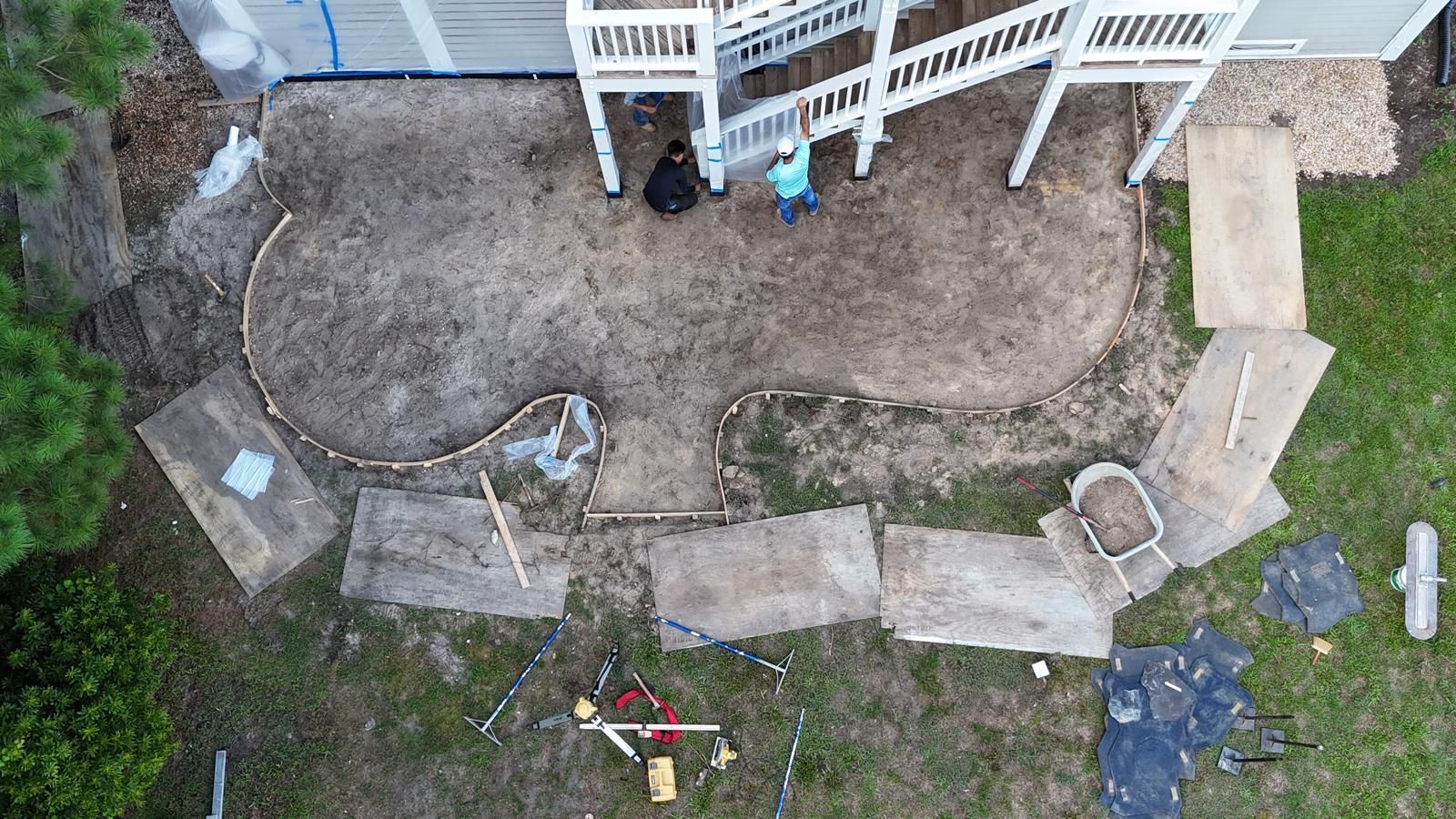 An aerial view of a patio being built in front of a house.
