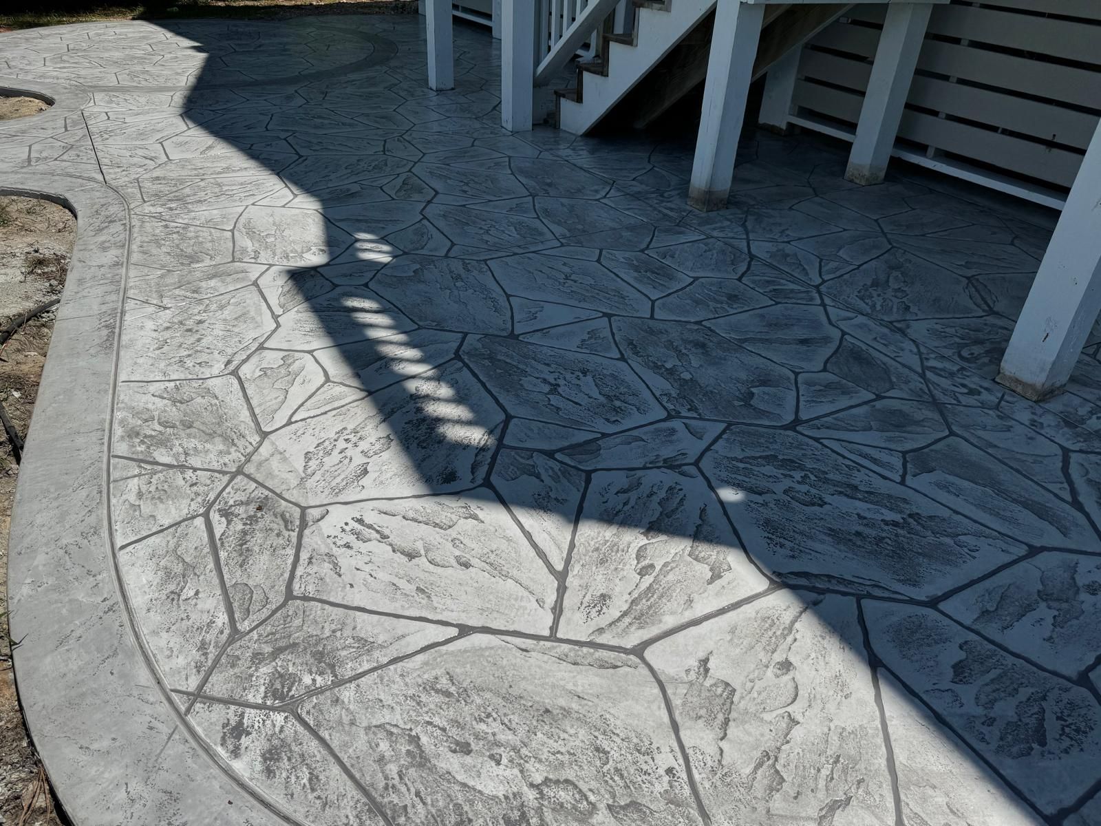 A concrete walkway with a staircase in the background