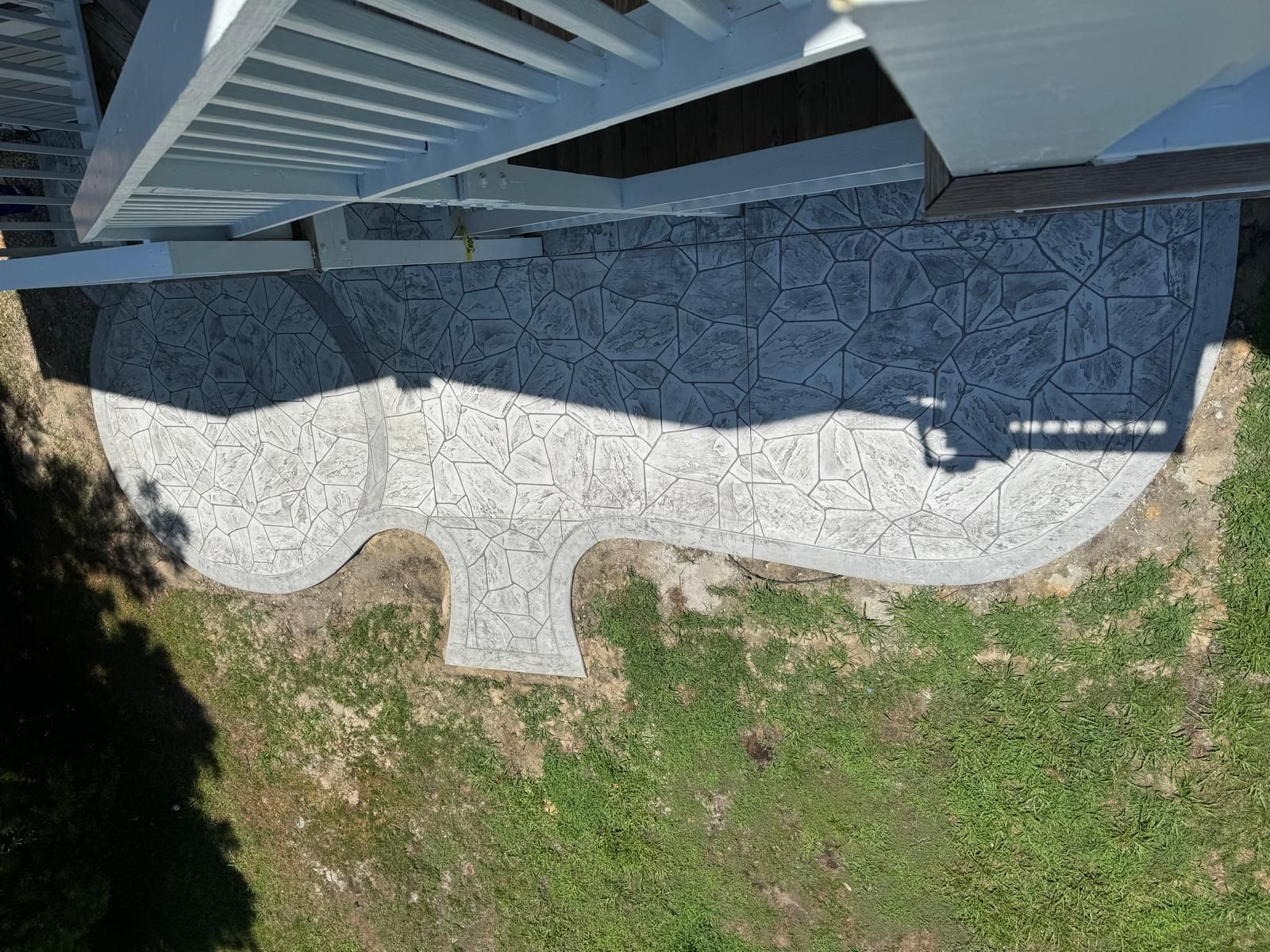 An aerial view of a concrete walkway leading to a deck.