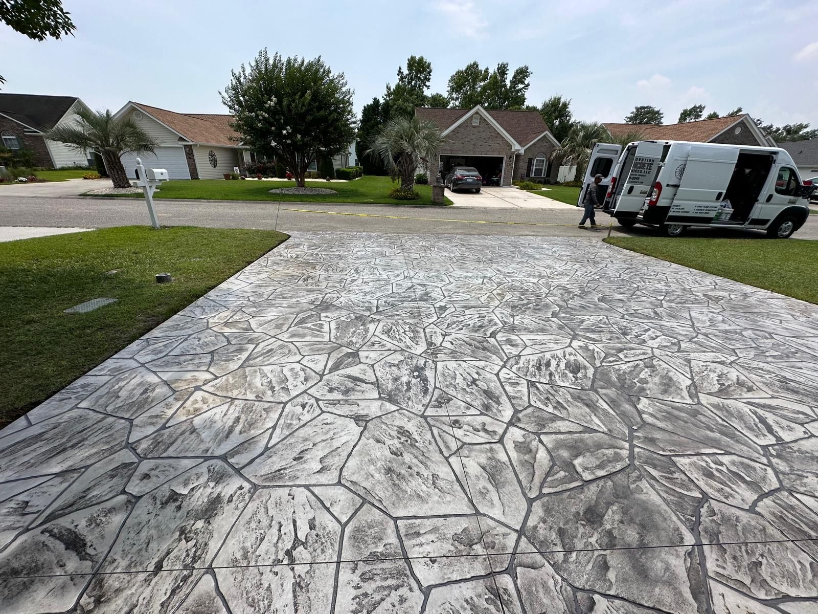 A white van is parked in the driveway of a house