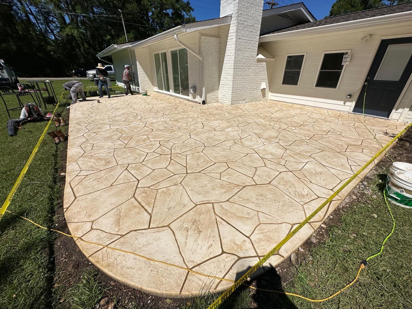 A concrete patio is being built in front of a house.
