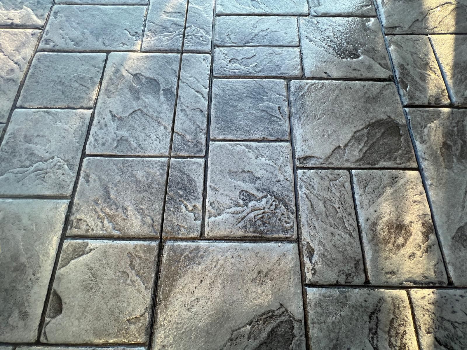 A close up of a brick floor with a shadow on it