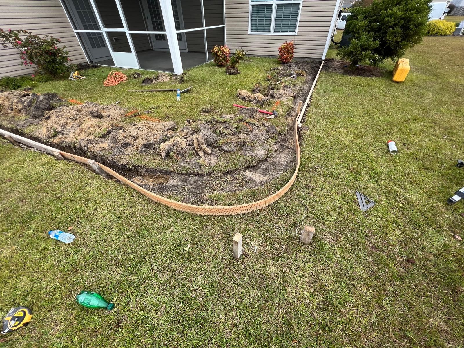 A lawn with a concrete curb in front of a house.