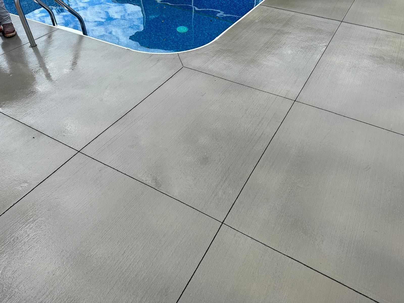 A concrete floor next to a swimming pool.