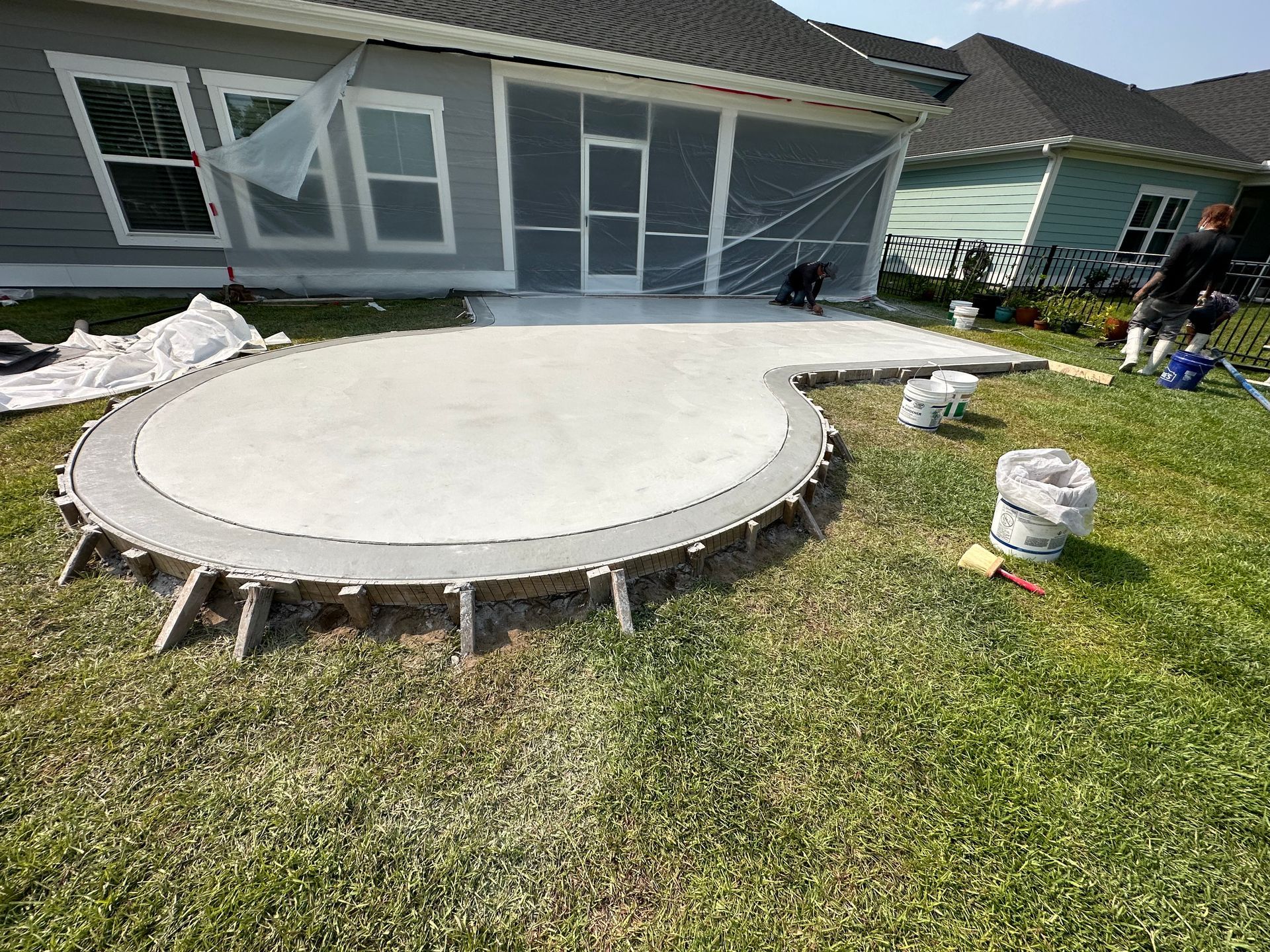 A concrete patio is being built in front of a house.