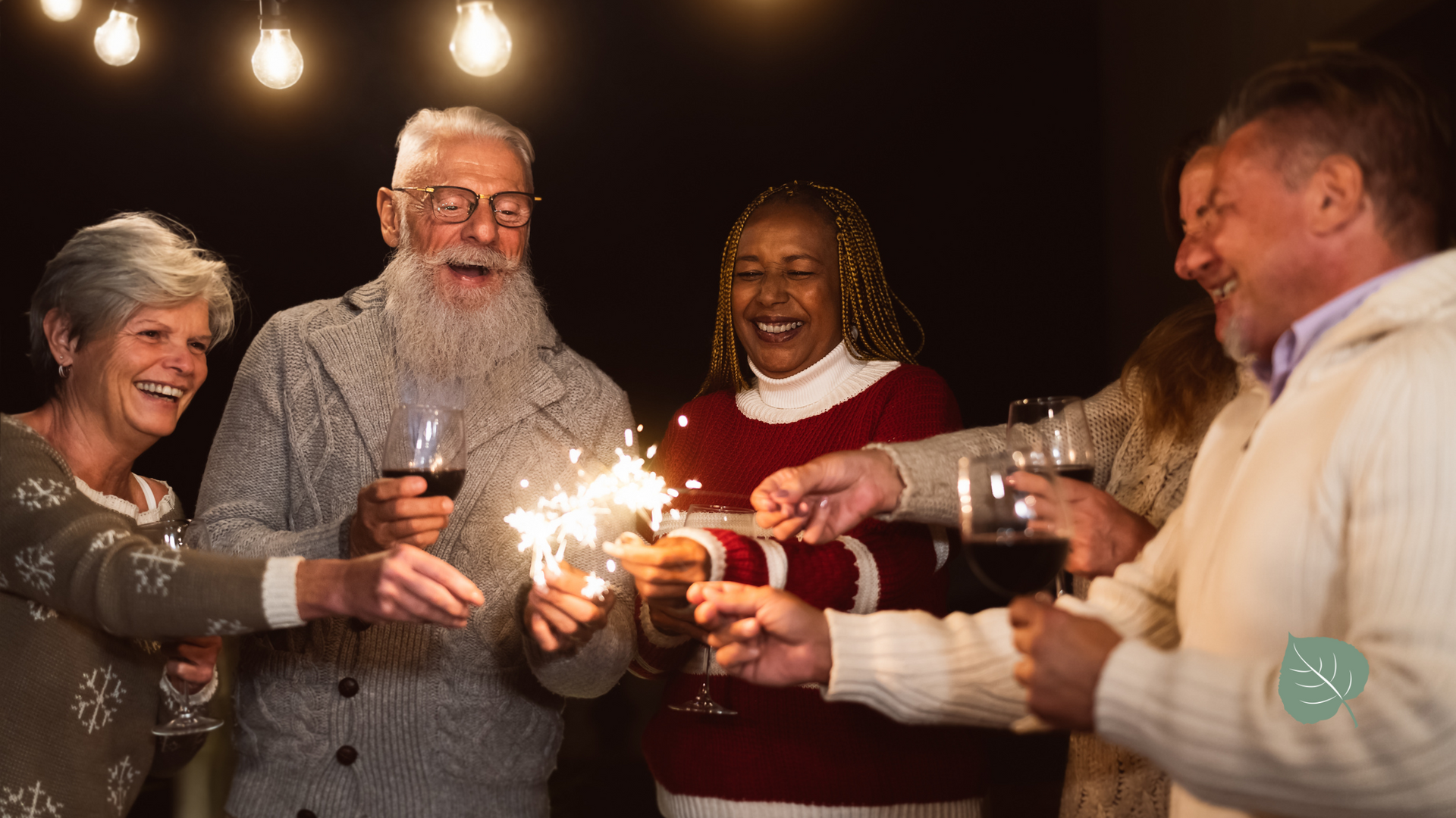 A group of people are holding sparklers and drinking wine.