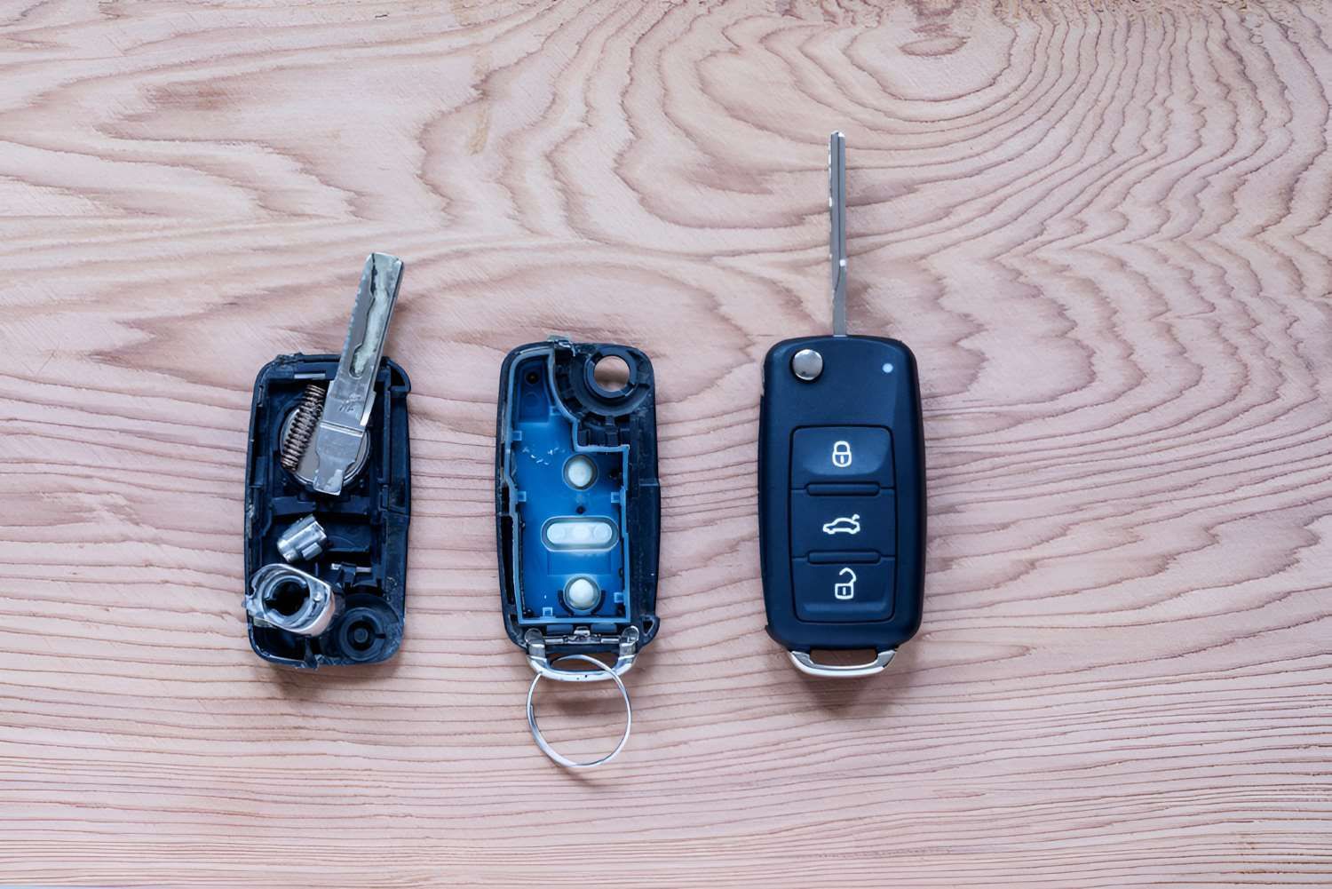 Three Car Keys Are Sitting on a Wooden Table — Fraser Mobile Auto Tech in Tolga, QLD