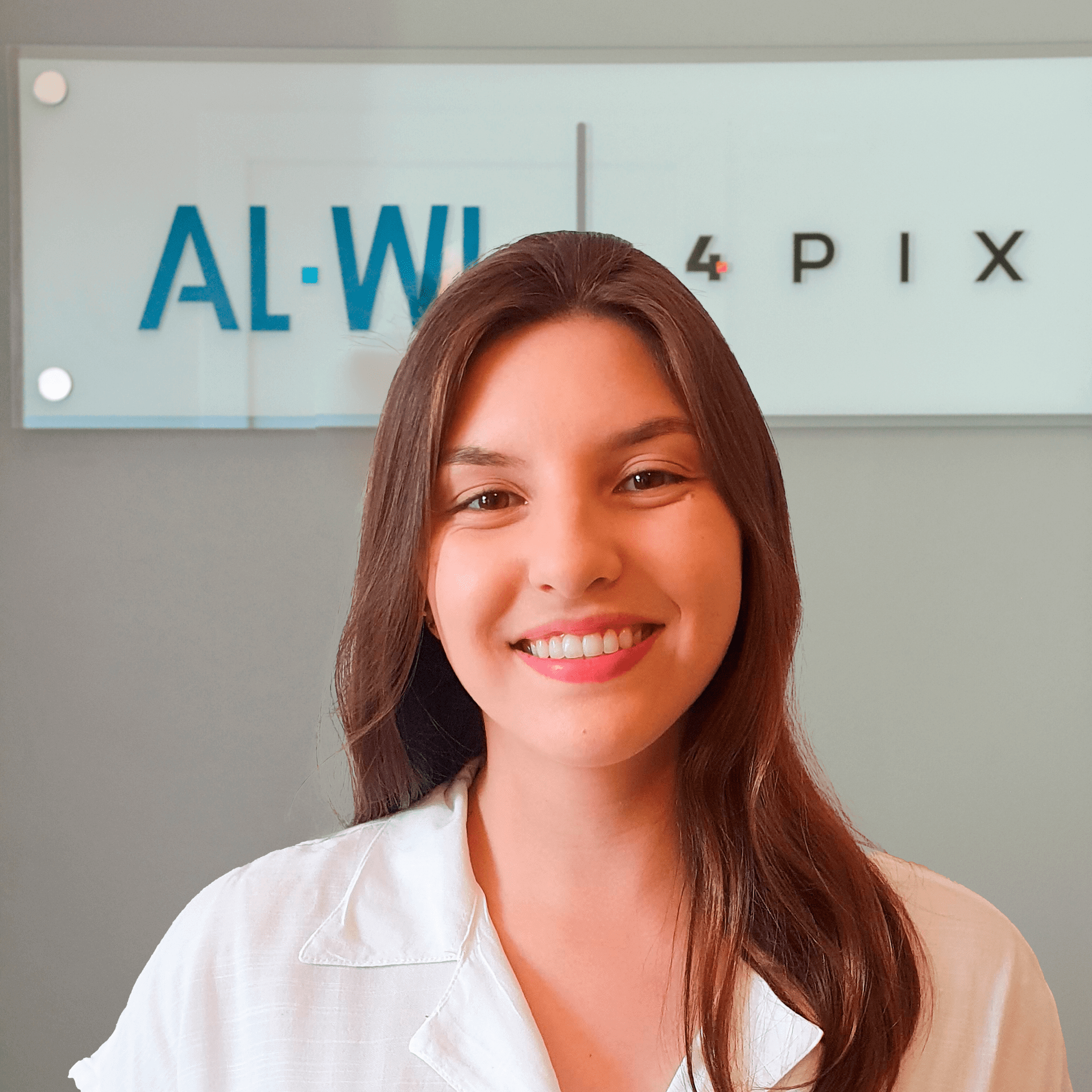 Uma mulher sorri na frente de uma placa que diz al-wi 4 pix
