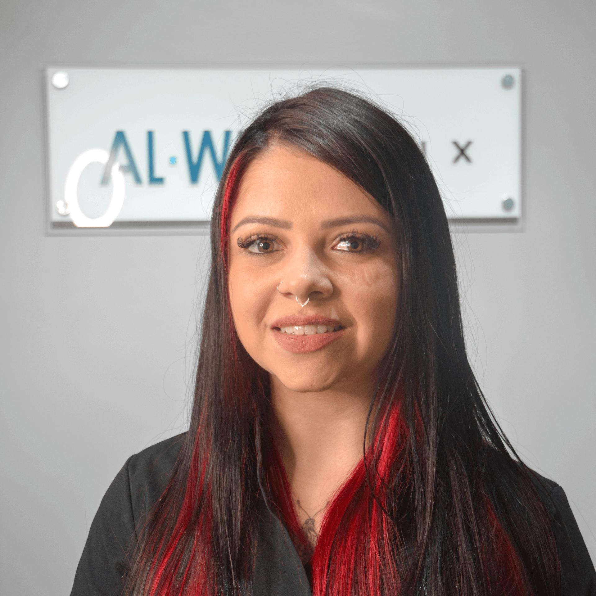 Uma mulher ruiva está parada em frente a uma placa que diz cal-wx