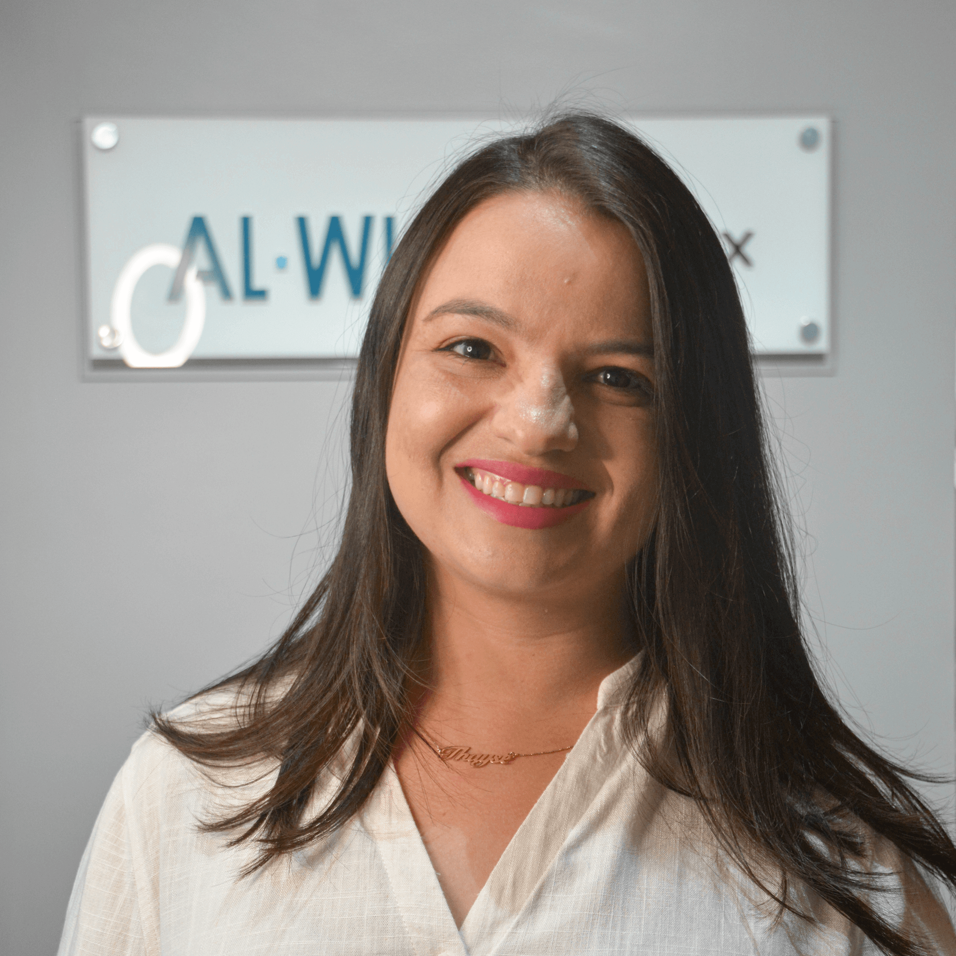 Uma mulher está sorrindo na frente de uma placa que diz cal-wix
